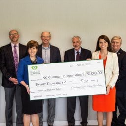 Group of people holding a big check