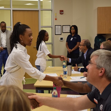 Children shaking hands with adults