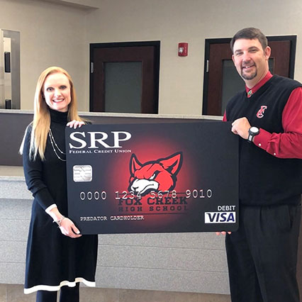 Man and woman holding large check with SRP Credit Union logo on it